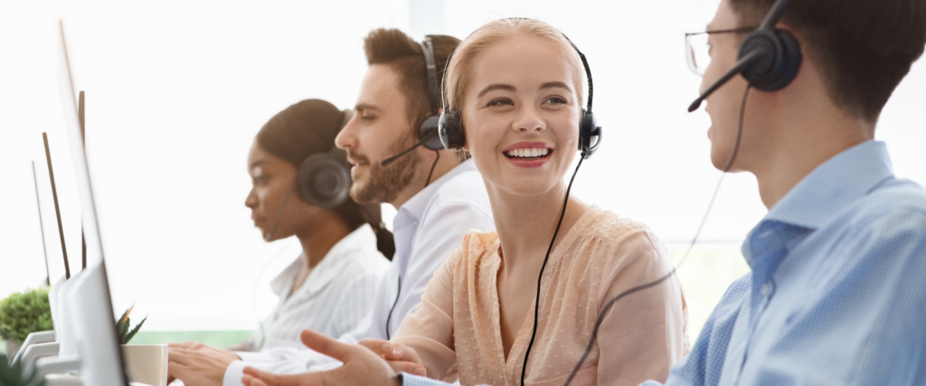 Customer service team working at desks, wearing headsets.